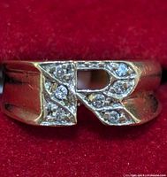 Top view of ring showing letter 'R' motif paved with diamonds
