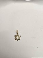 Close-up photo of the 10k gold pendant shaped as a leaf with a bail for chain attachment.