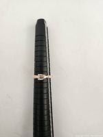 10k rose gold ring on ring sizer showing buckle design with diamond accents.