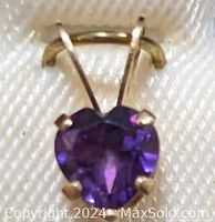 Close-up of heart-shaped amethyst gemstone set in yellow gold pendant, showing stone clarity and prong setting details.