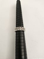 Ring on mandrel showing alternating baguette and round brilliant cut diamonds