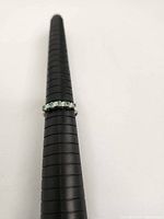 Front-on view of ring on mandrel showing alternating stones