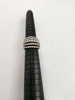 Ring positioned on black mandrel showing band profile and row arrangement.