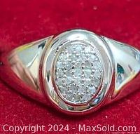 Top view showing the polished silver band and oval-shaped face with cluster of small diamonds.