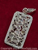 Front view of the silver diamond pendant showing teardrop stones and beaded border.