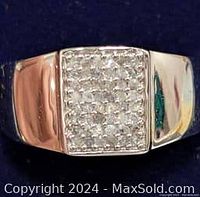 Front view of silver ring showing rectangular pave diamond setting on top part of the band with polished finish.