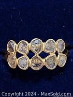 Front view of the silver ring with multiple clear diamond accent stones, showing the two-row design with irregular shaped stones in gold-tone bezels.