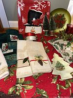 Image showing quilted placemats, embroidered napkins, Christmas plates, and decorative trees