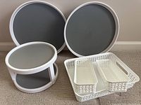 Two 15-inch diameter turntables, two-tiered 10-inch turntable, and three white perforated plastic organizer bins arranged on floor