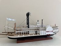Side view of the detailed Mississippi Riverboat model on wood base showing the smokestacks, paddlewheel, and deck features.