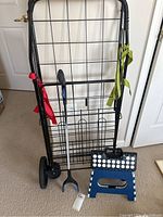 Full view of the folding shopping cart, grabber tool, and folding stool together showing physical condition and relative size
