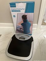 Newell digital bath scale with black platform and silver trim placed on floor, showing LCD display area