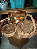 Image showing five woven baskets in various sizes and shapes with one basket containing assorted faux vegetables.