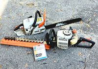 Full view of Echo chainsaw, hedge trimmer, and packaged saw chain on asphalt surface