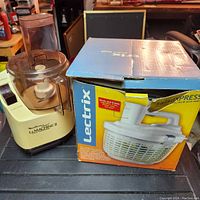 Lectrix La Machine II food processor next to the boxed SaladXpress salad spinner.