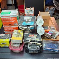 Overview showing assorted boxes and containers of hardware fasteners and screws with some wooden boxes and glue containers