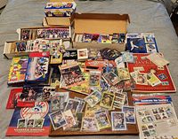 Wide view of two storage boxes, loose cards spread on table, stamp albums and wax box