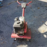 Full frontal view of the Yard Machines rototiller showing engine, tines, and handlebar setup.