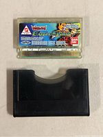 Front of Bandai Battle Spirit Digimon game card with label showing Digimon imagery and model details, placed above black cartridge holder.