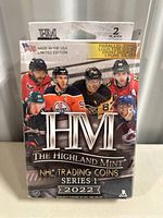 Front view of sealed Highland Mint 2022 NHL Series 1 trading coin box showing player images and branding.