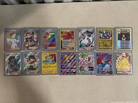 Front view of all 14 Pokemon cards laid out in a row, showing holographic and trainer cards in protective sleeves.