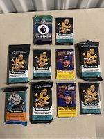 Top-down photo showing 10 sealed trading card packs laid out on a table, including multiple Upper Deck Parkhurst hockey card packs from 2020-21 and 2021-22 seasons and one Premier League soccer card pack from 2021-22 season.