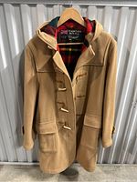 Front view of camel/beige vintage duffle coat with toggles and two front flap pockets.