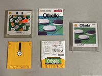Two Nintendo Famicom Disk System floppy disks with Othello and Mahjong games, and their instruction booklets.