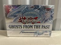 Front view of a sealed Yu-Gi-Oh Ghosts From The Past booster box showing the Blue-Eyes White Dragon artwork and label indicating English 1st edition