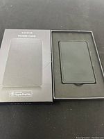 Box with sliding cover showing Ekster Finder Card packaging with Apple Find My compatibility.