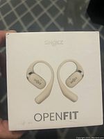 Front of box showing Shokz OpenFit wireless earbuds in beige color