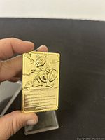 Back side of the card displaying embossed genetic information of Mewtwo with clear gold finish.