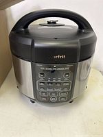 Full view of the Starfrit pressure cooker showing the top handle and front panel with digital display and control buttons.