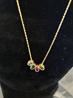 Close-up of the necklace pendant with five different colored stones set in gold-plated sterling silver.