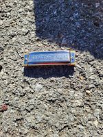 Top view of the harmonica showing engraved text on the metal cover plate.