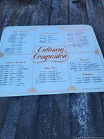 White cutting board with printed culinary companion cooking conversions, sauce packets, corn items, cereals and other cooking measurements on surface.