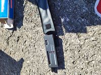 Diamond Selector II device placed on a rough asphalt surface, showing the entire body, on/off switch, and probe cable.