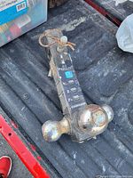 Photo of a chrome triple hitch ball mount with three different sized balls and an adjustable mount mechanism showing some usage wear and rust spots.