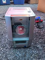 Front view of the JVC stereo CD player showing the circular CD compartment, controls, and power cable behind the device