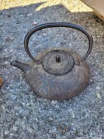 Full view of the tea pot showing the embossed bamboo leaf design and curved handle.