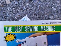 Close-up of packaging showing 'The Best Sewing Machine' branding and 'As Seen On T.V.' text