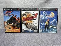 Three PlayStation 2 game cases standing upright showing front covers of ATV Offroad Fury, Burnout 3: Takedown, and Final Fantasy X.