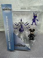 Front view of the Disney Kingdom Hearts Mickey, Assassin, and Shadow figures in original blister packaging with branding and character names visible.