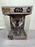 Front view of boxed chrome Mandalorian Funko Pop! figure #380 showing Mandalorian helmet and The Child inside the original transparent display case.