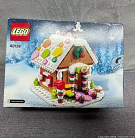 Front view of new sealed LEGO 2015 Limited Edition Gingerbread House set 40139 box showing the assembled gingerbread house with candy pieces on roof and candy cane pillars.