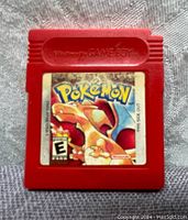 Front view of red Game Boy cartridge featuring Pokemon Red Version label with Charizard