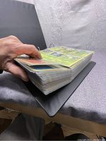 Side view of a thick binder filled with Pokémon cards in plastic sleeves.