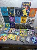 Wide photo showing entire lot with tins, cards, guides, and packs laid out for display