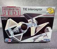Box front of the Star Wars Return Of The Jedi TIE Interceptor MPC snap model kit showing artwork of TIE Interceptor spacecraft and branding.