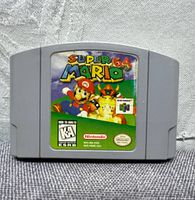Front view of gray Nintendo 64 cartridge with colorful Super Mario 64 label featuring Mario and Bowser characters.